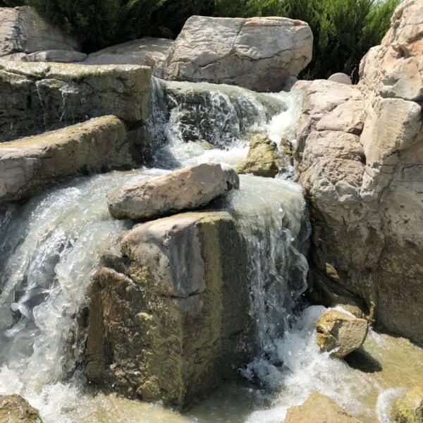 A closeup shot of water running down some artificial boulders located in Benbrook Texas.