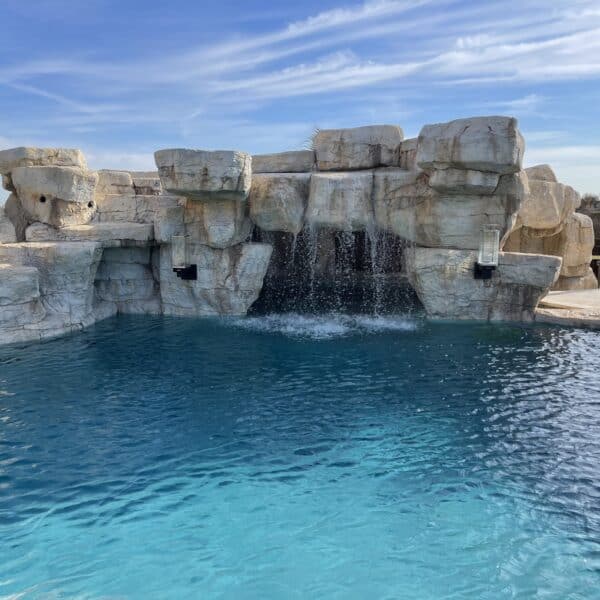 Large pool with large water feature and waterfalls.